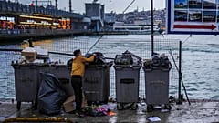 Bir çöp toplayıcısı, İstanbul Karaköy'de çöp atarken görüntüleniyor (Arşiv)