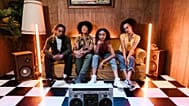 Four young people sitting in a retro-themed room. 