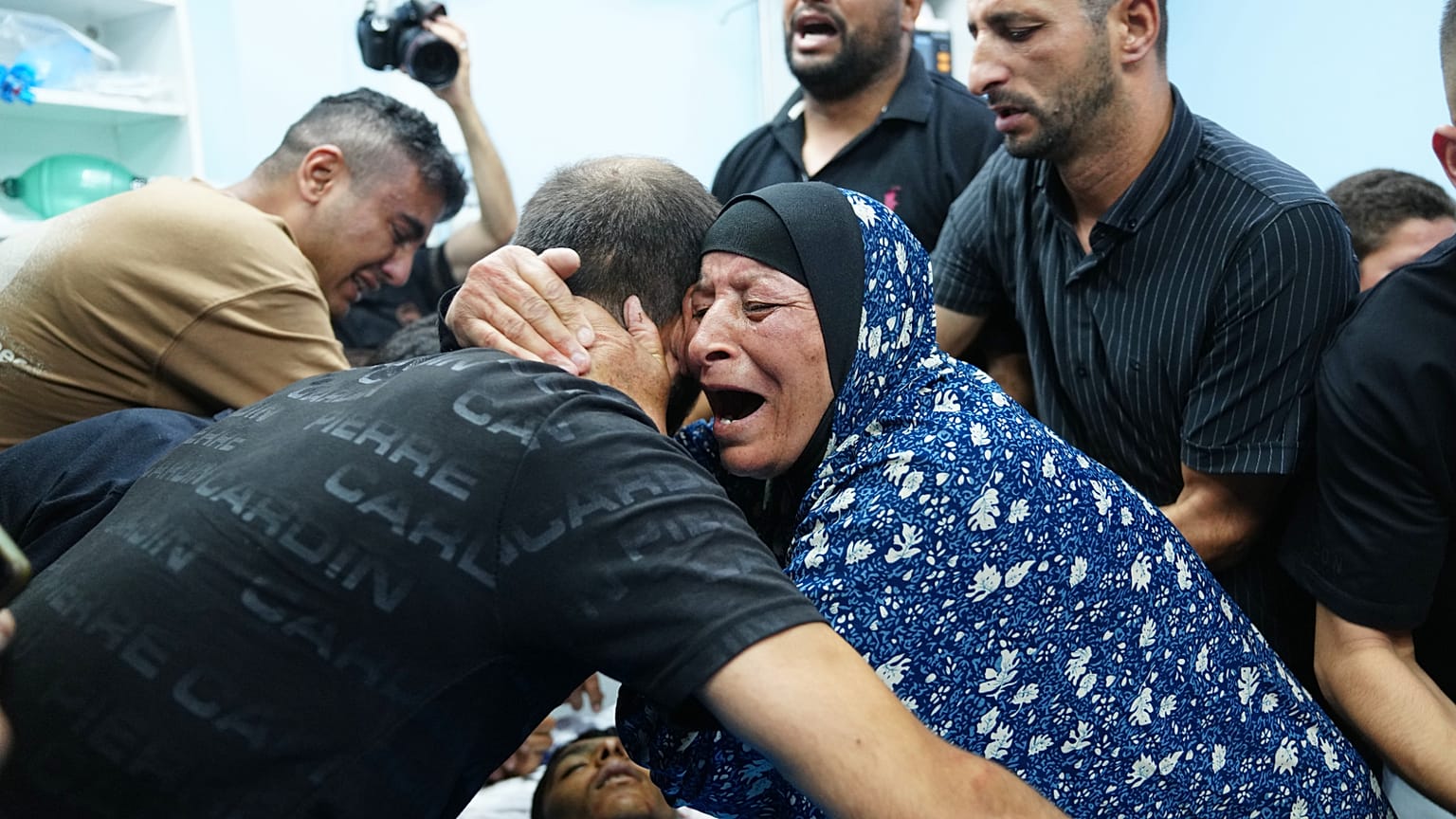 أقارب الفلسطيني كريم شلالده، 17 عاماً، يبكون على جثته في مستشفى بمدينة الخليل بالضفة الغربية، الجمعة 21 أغسطس 2026. (AP Photo/محمود إيلين)