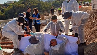 Trabajadores funerarios depositan en una tumba el cuerpo de un migrante que falleció al intentar cruzar de Marruecos a Ceuta, el 21 de agosto de 2026.
