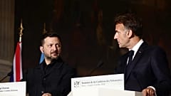 Ukrainian President Volodymyr Zelensky, left, and French President Emmanuel Macron address a press conference after a Coalition of the Willing summit.