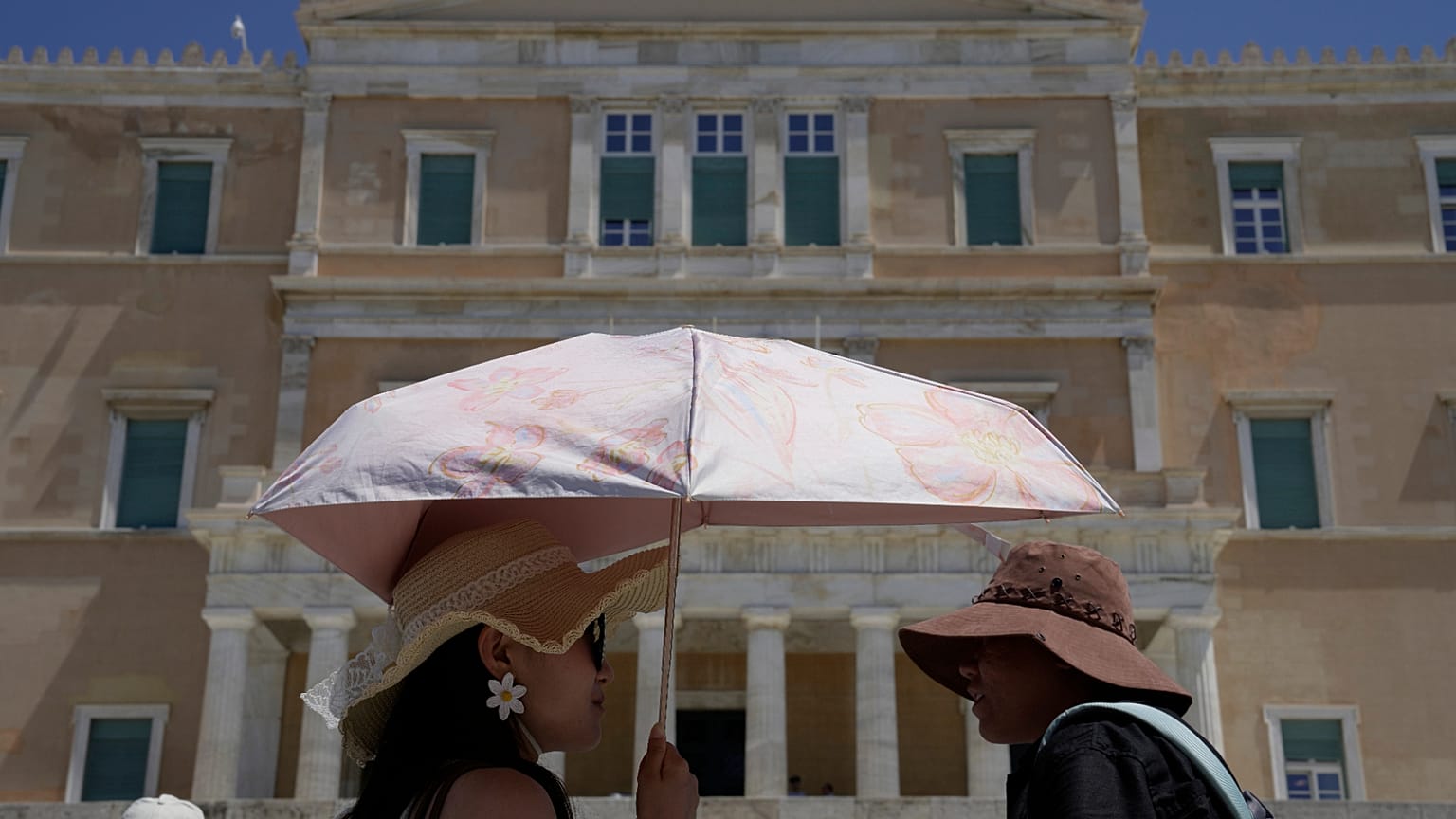 Τουρίστες με καπέλα και ομπρέλα στο κέντρο της Αθήνας