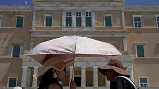 Τουρίστες με καπέλα και ομπρέλα στο κέντρο της Αθήνας