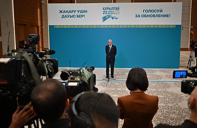 Tokayev answers questions from journalists at a polling station.