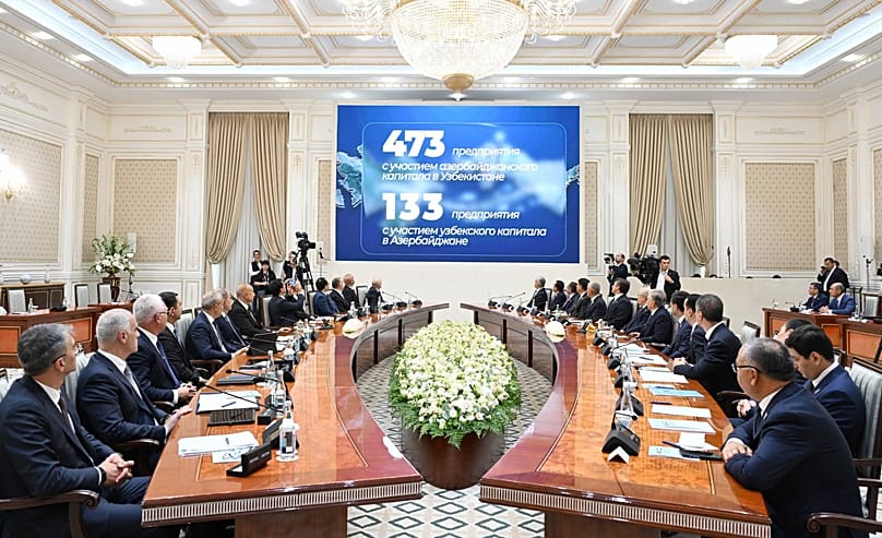 Узбекская и азербайджанская делегации участвуют в заседании Высшего межгосударственного совета в Ташкенте; на экранах демонстрируются показатели двусторонних инвестиций.