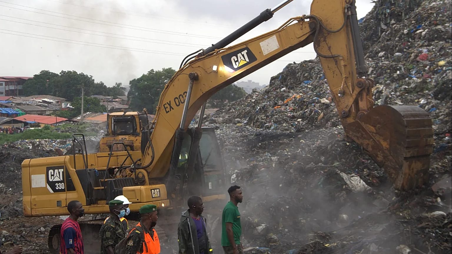 Rescue workers search through a heap of refuse after it collapsed at Conakry’s largest landfill, Guinea, Sunday, Aug. 23, 2026.