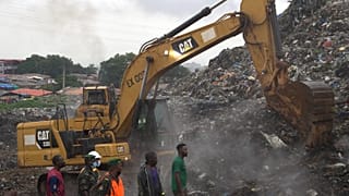 Rescue workers search through a heap of refuse after it collapsed at Conakry’s largest landfill, Guinea, Sunday, Aug. 23, 2026.