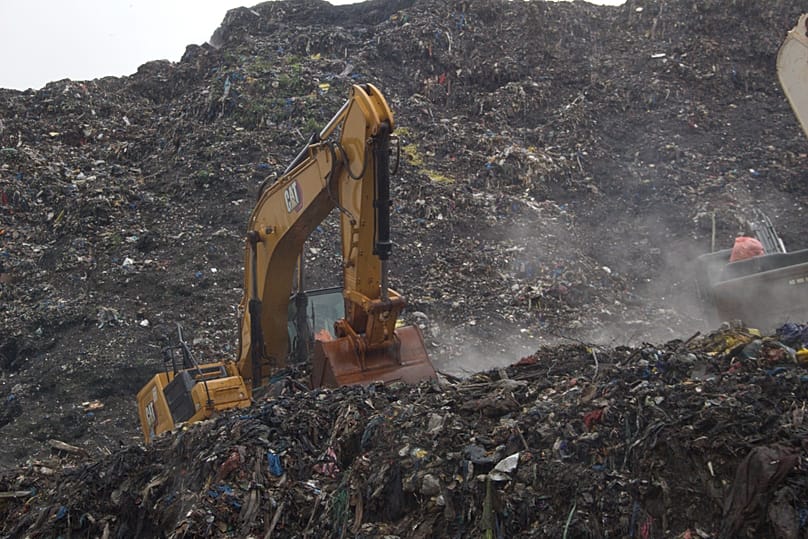 Rescue workers search through a heap of refuse after it collapsed at Conakry’s largest landfill, Guinea, Sunday, Aug. 23, 2026.
