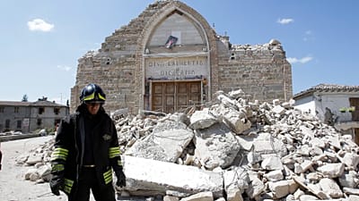 Un vigile del fuoco passa accanto ai resti di una chiesa a Villa San Lorenzo, vicino ad Amatrice, nell'Italia centrale, sabato 27 agosto 2016.
