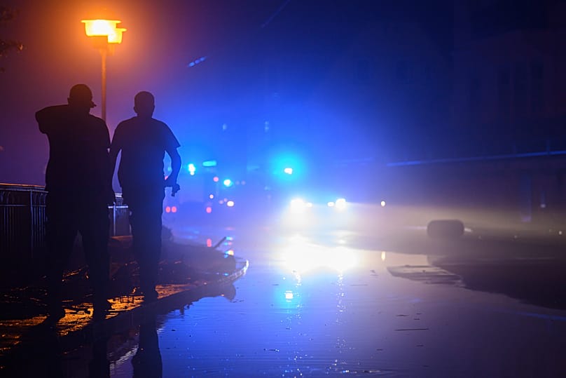 Police officers stand near to a police vehicle in front of a house in Leipzig Connewitz, 24 April, 2024