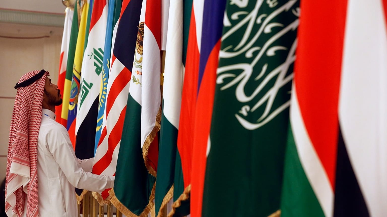 عامل سعودي يقوم بتعديل أعلام الدول المشاركة قبل اجتماع وزراء الطاقة من أوبك وحلفائها لمناقشة الأسعار وخفض الإنتاج، في جدة بالمملكة العربية السعودية، الأحد 19 مايو 2019. 