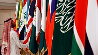 عامل سعودي يقوم بتعديل أعلام الدول المشاركة قبل اجتماع وزراء الطاقة من أوبك وحلفائها لمناقشة الأسعار وخفض الإنتاج، في جدة بالمملكة العربية السعودية، الأحد 19 مايو 2019. 