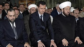 الرئيس السوري المخلوع بشار الأسد (في الوسط)، ومفتي سوريا السابق أحمد بدر الدين حسون (إلى اليمين)، يؤديان الصلاة يوم الأربعاء، 19 مارس/آذار 2008، في مسجد التقوى بوسط دمشق.
