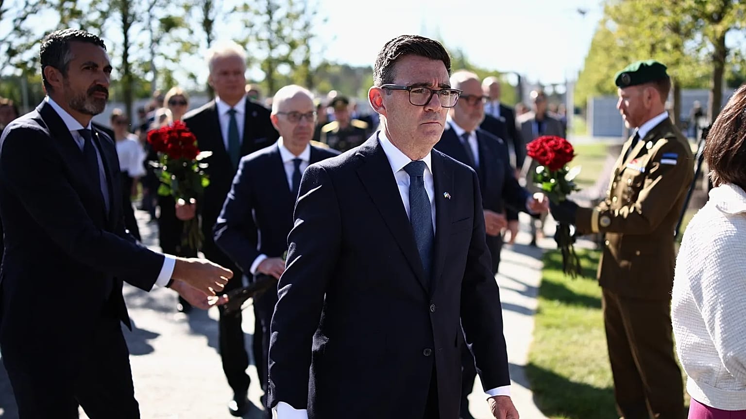 Britain's Prime Minister Andy Burnham, center, takes part in a wreath-laying ceremony at Ukraine's national military memorial cemetery in Hatne, southwest of Kyiv, Ukraine.