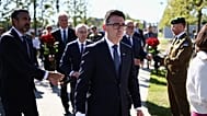 Britain's Prime Minister Andy Burnham, center, takes part in a wreath-laying ceremony at Ukraine's national military memorial cemetery in Hatne, southwest of Kyiv, Ukraine.