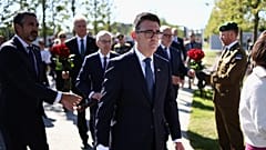 Britain's Prime Minister Andy Burnham, center, takes part in a wreath-laying ceremony at Ukraine's national military memorial cemetery in Hatne, southwest of Kyiv, Ukraine.