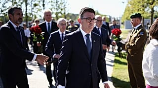 Britain's Prime Minister Andy Burnham, center, takes part in a wreath-laying ceremony at Ukraine's national military memorial cemetery in Hatne, southwest of Kyiv, Ukraine.