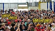 People wait for Donald Trump to arrive at an event at the General Motors Proving Ground in Milford, Michigan, July 27, 2026.