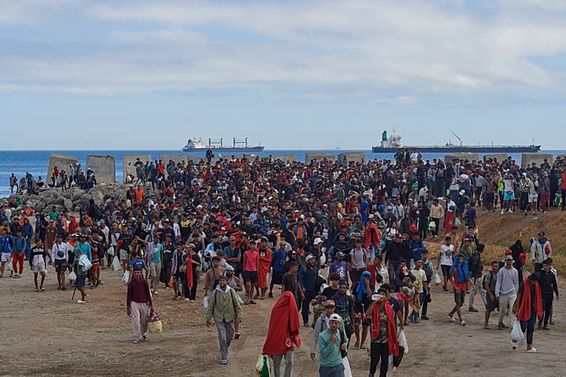Migrants who crossed from Morocco into Spain are escorted by Spanish police to temporary shelters after being cleared from a beach in Ceuta, 21 August, 2026