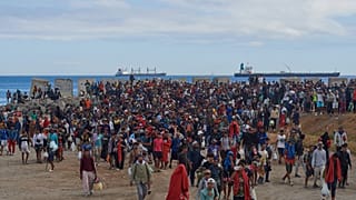 Migrantes que cruzaron de Marruecos a España regresan a una playa tras haber sido expulsados ​​de la zona el día anterior en Ceuta, el viernes 21 de agosto de 2026