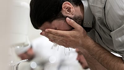 رجل يتوضأ قبل أداء الصلاة.
