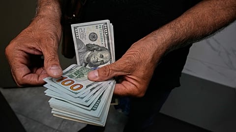 صراف يعدّ أوراقًا نقدية من فئة الدولار الأميركي في ساحة الفردوسي، أحد أبرز مراكز تداول العملات الأجنبية وسط العاصمة الإيرانية طهران، الاثنين 24 آب/أغسطس 2026.