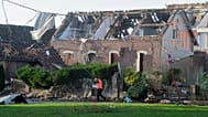 A rescue worker passes a tornado-damaged house in Bihucourt, northern France, Monday, Oct. 24, 2022.
