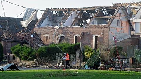Un soccorritore passa accanto a una casa danneggiata da un tornado a Bihucourt, nel nord della Francia, lunedì 24 ottobre 2022.