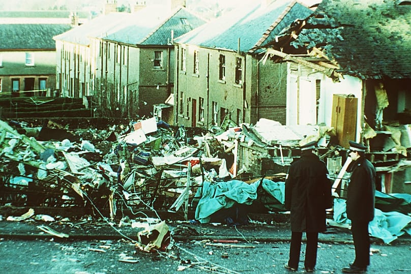 Two police officers view the shell of a wrecked house in the centre of Lockerbie, 23 December, 1988