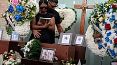 جيرفينسون كوفا وستيفاني لانداييز يحتضنان بعضهما البعض خلال جنازة طفليهما وأعضاء آخرين من عائلة لانداييز الذين لقوا حتفهم في الزلزالين المزدوجين اللذين ضربا لا جويرا
