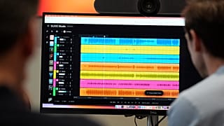 Na ekranie komputera widać przebiegi dźwięku z różnych instrumentów podczas tworzenia utworu muzycznego AI w SUNO.