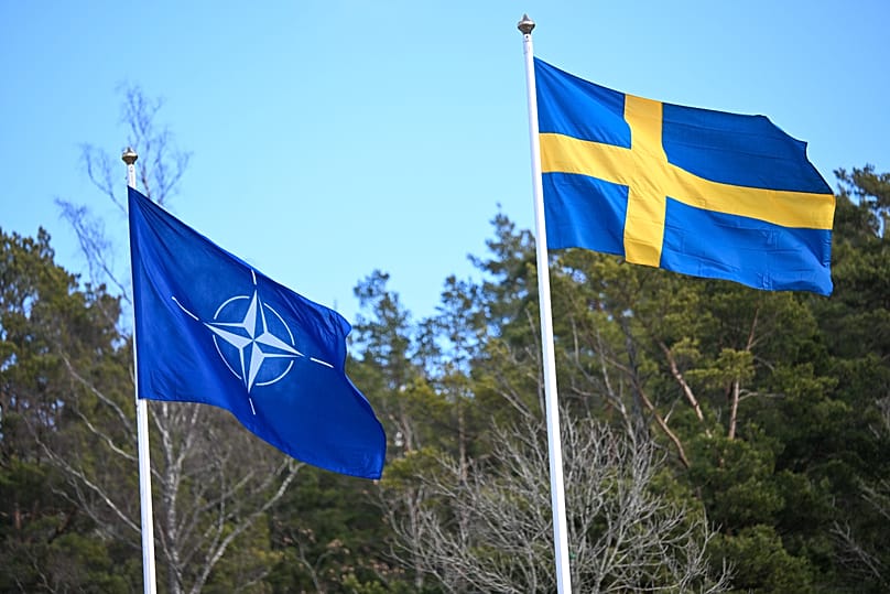 Bandeira da NATO içada ao lado da bandeira sueca durante uma cerimónia na base naval de Muskö, em Estocolmo, 11 de março de 2024
