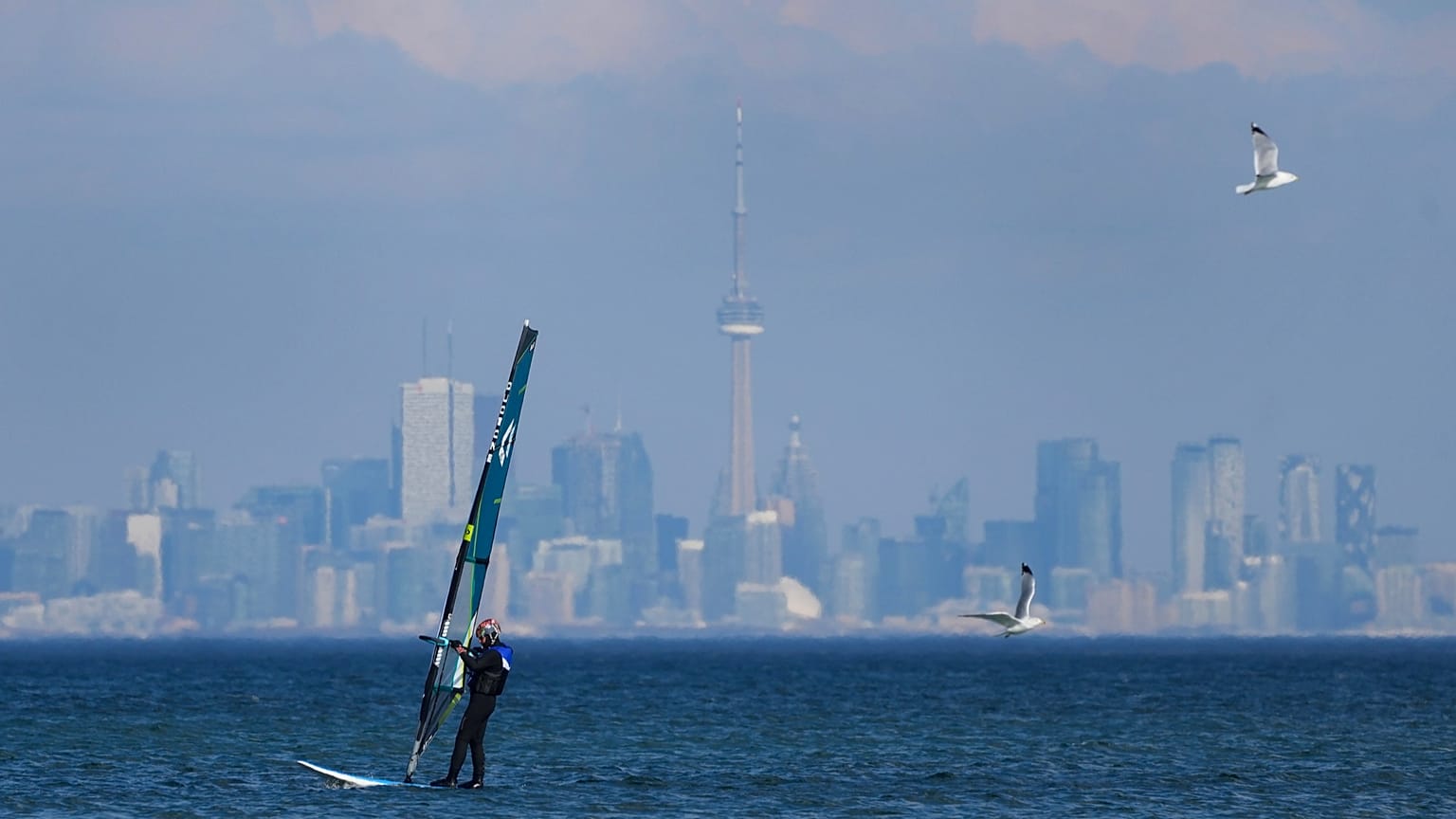 A windsurfer cuts through the waves along Lake Ontario overlooking the City of Toronto in Mississauga, 9 February, 2024