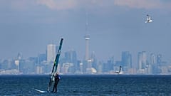 A windsurfer cuts through the waves along Lake Ontario overlooking the City of Toronto in Mississauga, 9 February, 2024