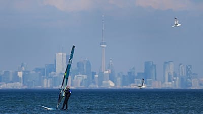 Un véliplanchiste fend les vagues sur le lac Ontario, avec Toronto en arrière-plan, à Mississauga, le 9 février 2024