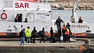 Migrants board an Italian Coast Guard vessel as part of a transfer operation from the asylum processing centres at the port of Shengjin, Albania.