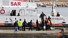 Migrants board an Italian Coast Guard vessel as part of a transfer operation from the asylum processing centres at the port of Shengjin, Albania.