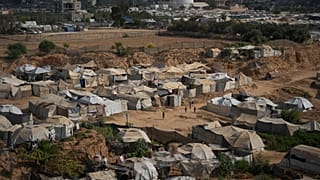 أطفال فلسطينيون يلعبون في منطقة مفتوحة في مخيم مؤقت للنازحين في دير البلح، وسط قطاع غزة، الجمعة 7 أغسطس/آب 2026. (صورة من وكالة أسوشيتد برس/عبد الكريم حنا)