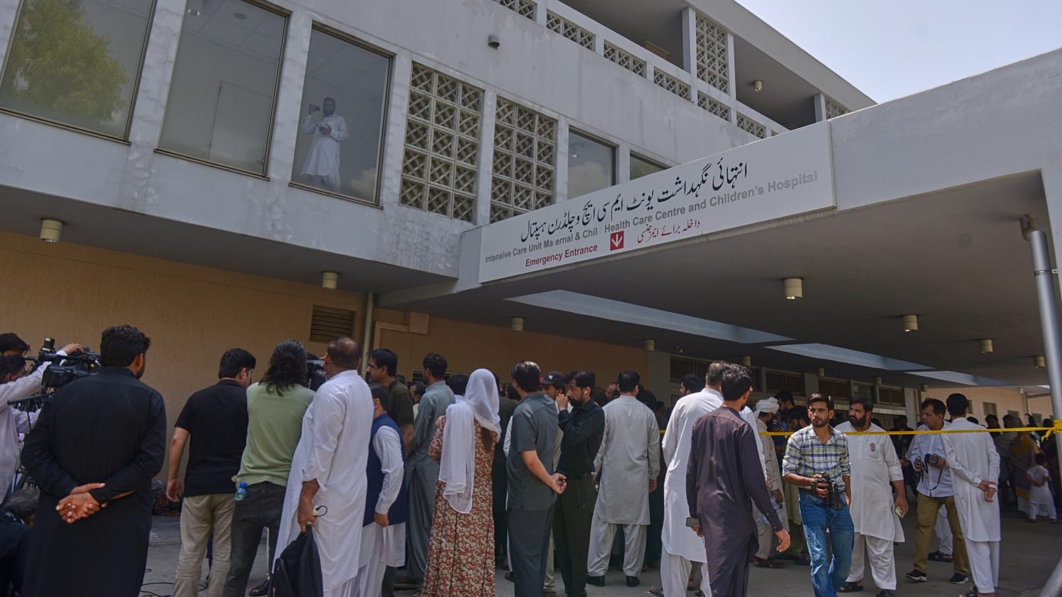 People gather outside a nursery in the gynaecology ward following a fire at a hospital in Islamabad, 26 August, 2026
