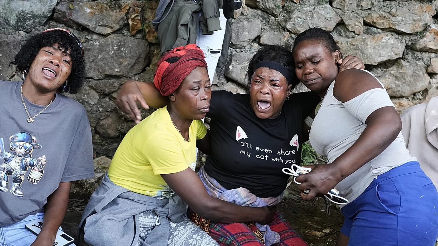 Women cry at the site where their relatives were killed in a gang attack in the Kenscoff neighborhood of Port-au-Prince, Haiti, Monday, 24 Aug, 2026. 