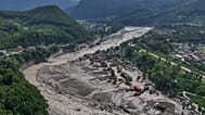 Damaged houses stand precariously near the swollen, debris-choked banks of the Trishuli River after flash floods in Nepal's Nuwakot district on Wednesday, Aug. 26, 2026. 