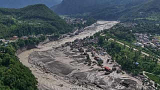 Damaged houses stand precariously near the swollen, debris-choked banks of the Trishuli River after flash floods in Nepal's Nuwakot district on Wednesday, Aug. 26, 2026. 
