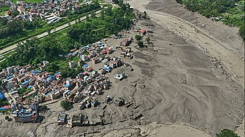 Damaged houses stand precariously near the banks of the Trishuli River after flash floods in the Nuwakot district, 26 August, 2026
