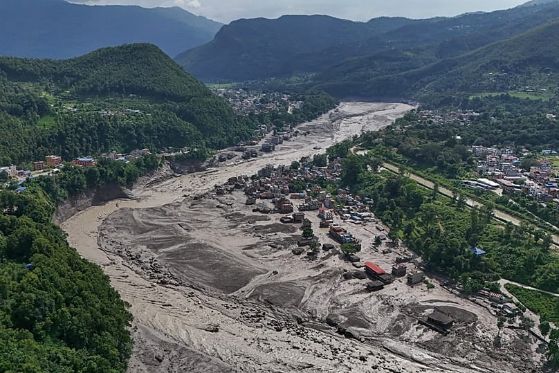 Damaged houses stand precariously near the banks of the Trishuli River after flash floods in the Nuwakot district, 26 August, 2026