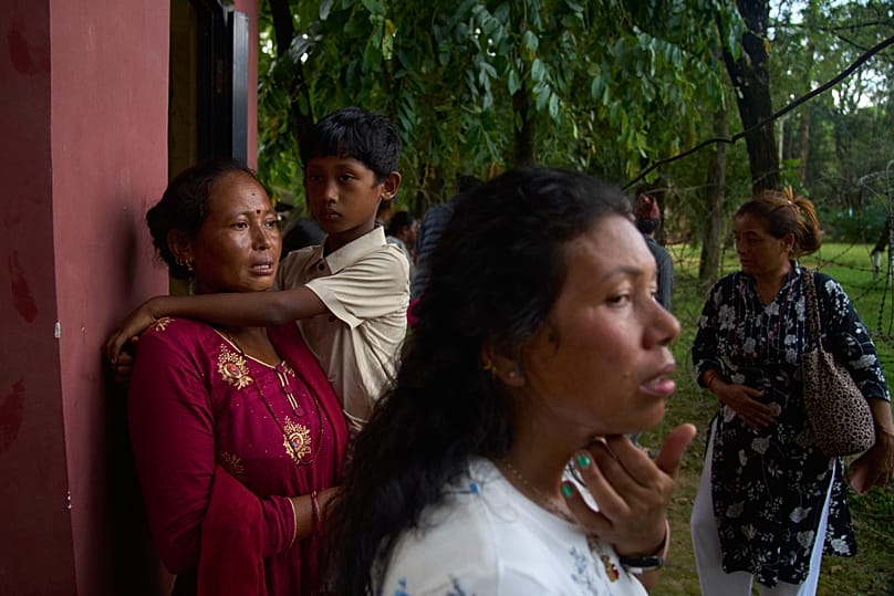 Personas esperan noticias de sus familiares desaparecidos tras las inundaciones repentinas a lo largo del río Trishuli en el distrito de Nuwakot, Nepal, 26 de agosto de 2026.