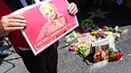 Actor Gregg Donovan holds a poster over Dolly Parton's star on the Hollywood Walk of Fame on Tuesday, Aug. 25, 2026, in Los Angeles.