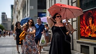 Archivio. Una donna tiene un ombrello per ripararsi dal sole durante una calda giornata di sole a Madrid, in Spagna.