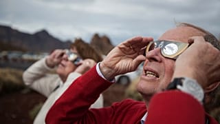 La gente observa cómo la Luna pasa por delante del Sol durante un eclipse solar parcial en Santa Cruz de Tenerife, en las Islas Canarias (España), 3 de noviembre de 2013.