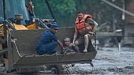 Rescuers use an earthmover to carry a victim of flash flooding to safety along the Trishuli River in Nepal's Nuwakot district, Wednesday, Aug. 26, 2026. (AP Photo/Niranjan Shr