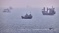 A small boat sails past cargo ships and other commercial vessels anchored in the Strait of Hormuz off Bandar Abbas, Iran, Wednesday, Aug. 5, 2026. (Amirhosein Khorgooi/ISNA vi